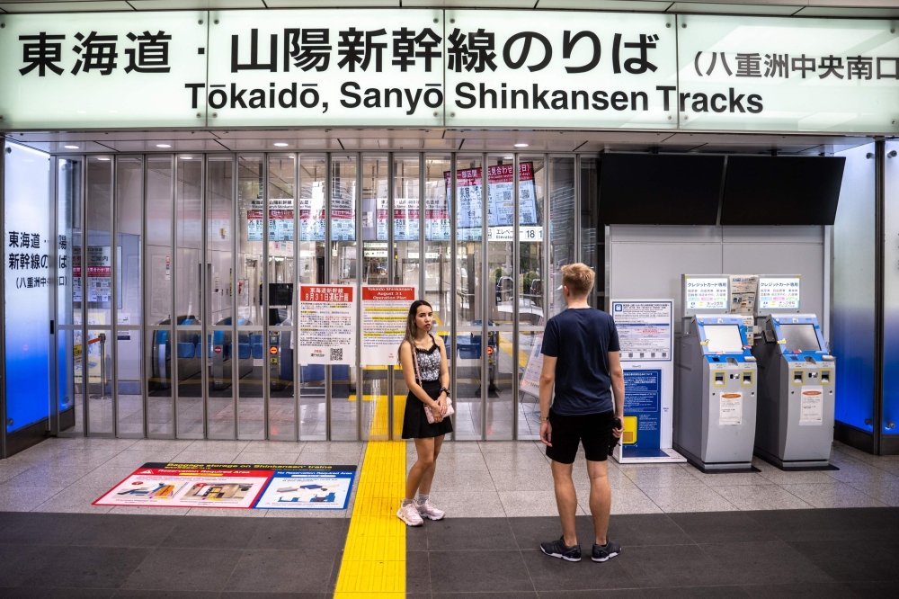 People stand in front of closed ticket gates for the Tokaido Shinkansen as train operations between Tokyo and Nagoya are suspended, in Tokyo Station, due to Typhoon Shanshan crawling across Japan on August 31, 2024. — AFP pic