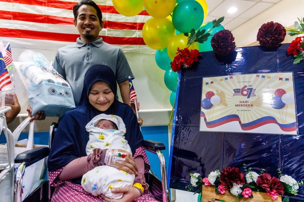 Iffatun Nisa Abdul Halim (seated) and Adli Uqasha Abd Malik pose with their Merdeka boy at Hospital Putrajaya on August 31, 2024. — Picture by Firdaus Latif