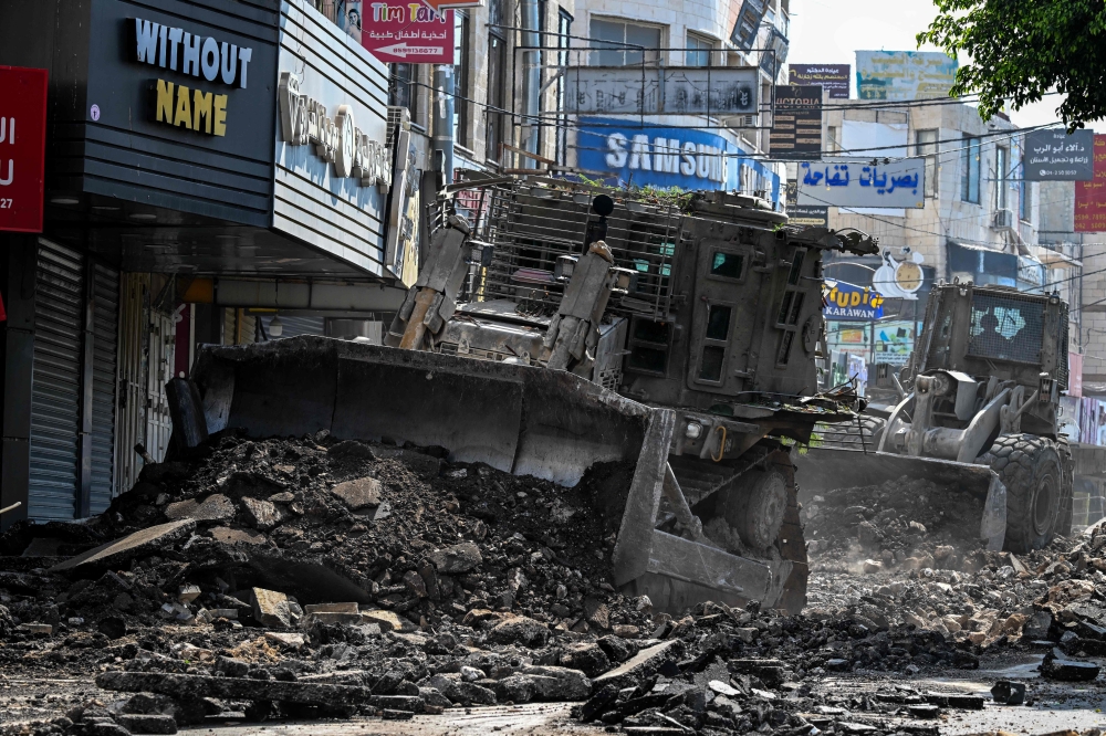 Israeli bulldozers tear up a street during an Israeli raid in the occupied West Bank city of Jenin on September 1, 2024. — AFP pic