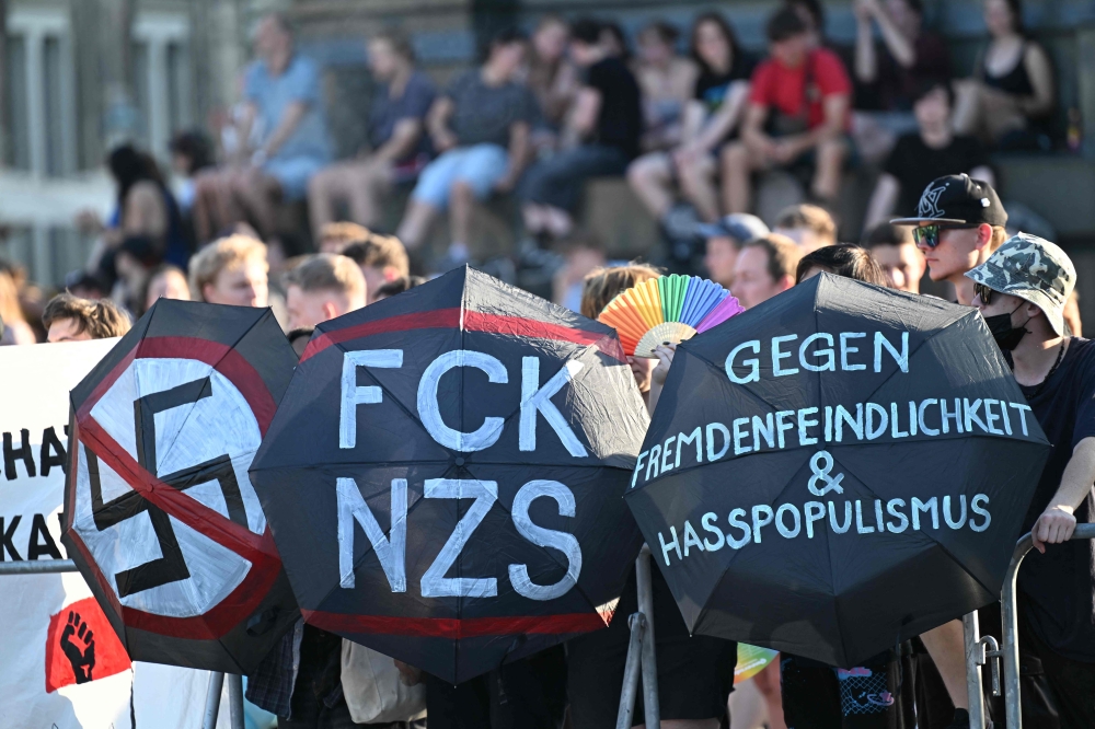 Counter-demonstrators use umbrellas with the wording 