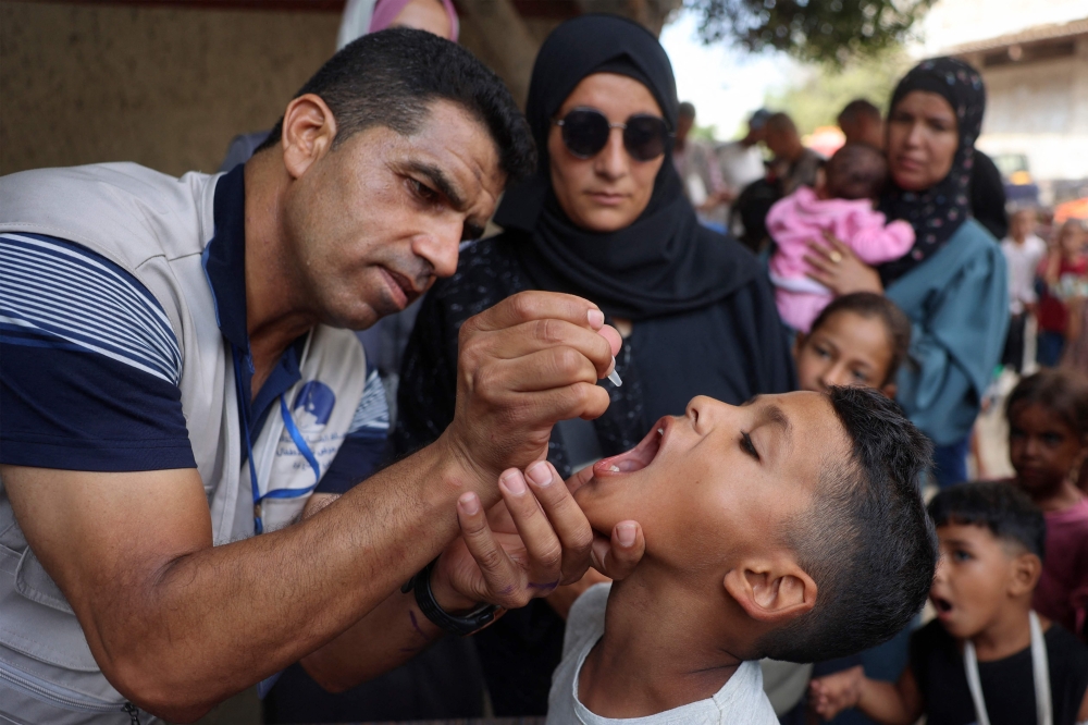  A health worker administers the Polio vaccine to a Palestinian child in Zawayda in the central Gaza Strip yesterday — AFP
