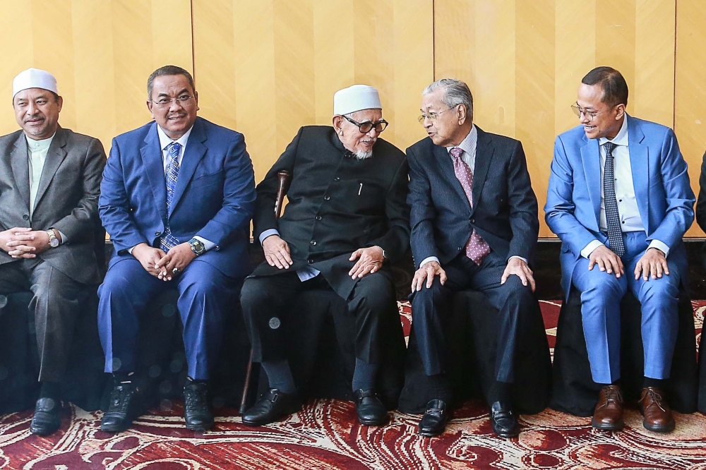 Former Prime Minister Tun Dr Mahathir Mohamad whisper to Advisor Panel Tan Sri Abdul Hadi Awang while having a group photo during the State Government 4 Summit here at Tenera Hotel. — Picture by Sayuti Zainudin