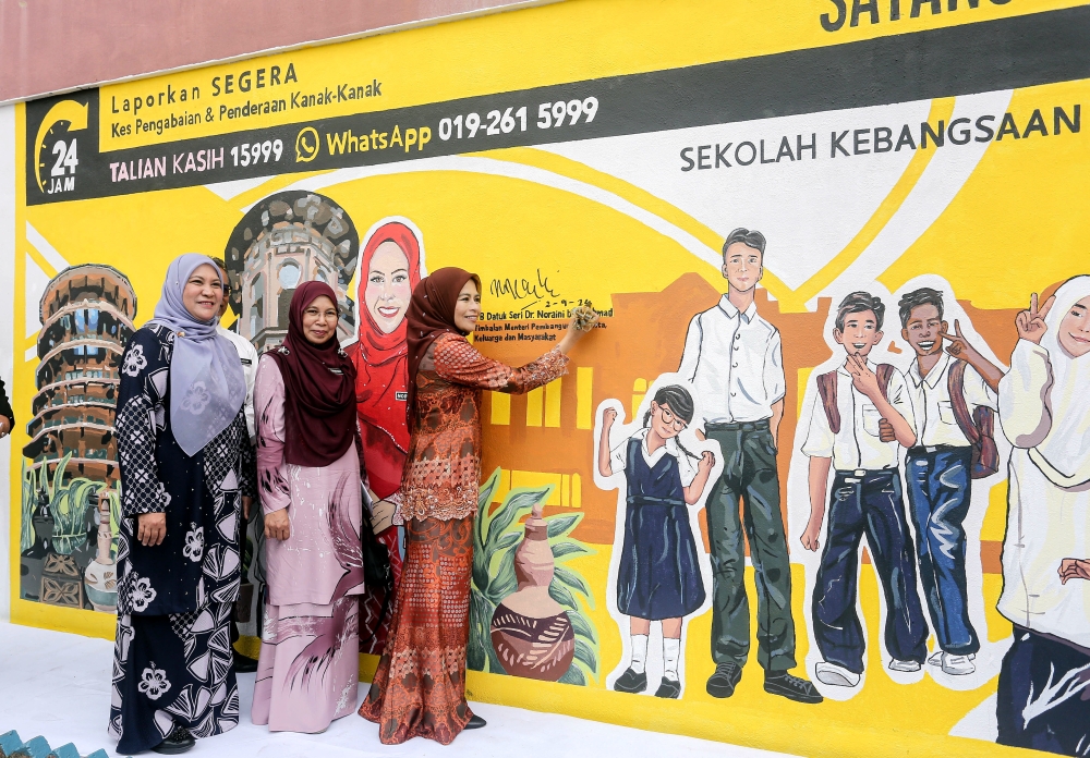 Women, Family and Community Development Deputy Minister Datuk Seri Noraini Ahmad (right) signs a mural at the Perak-level 2024 Child Protection Advocacy Programme: Love for Children at Sekolah Kebangsaan (SK) Seri Kelebang, Chemor, Ipoh September 2, 2024. — Bernama pic