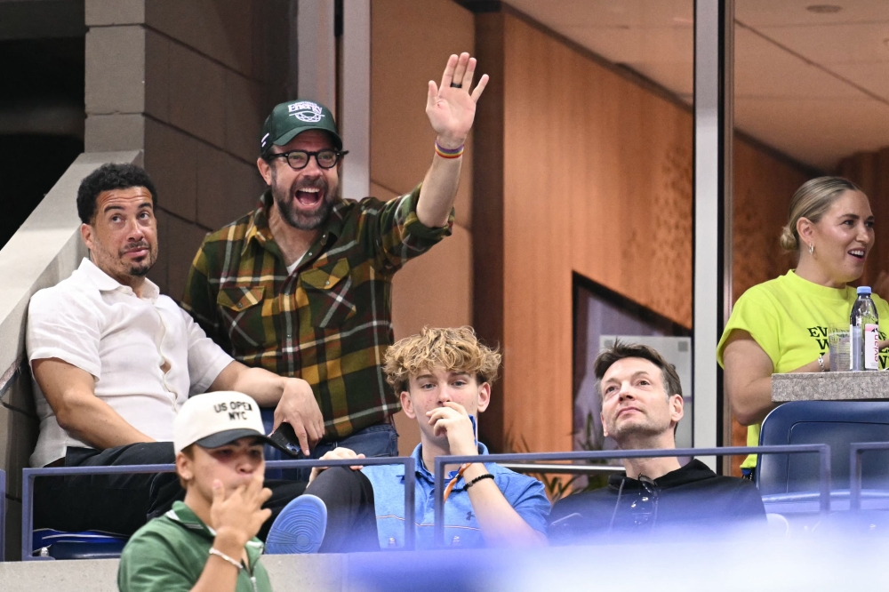 US actor and writer Jason Sudeikis (2nd left) waves as he attends the women's singles round of 16 match between Poland's Iga Swiatek and Russia's Liudmila Samsonova, on September 2, 2024. — AFP pic