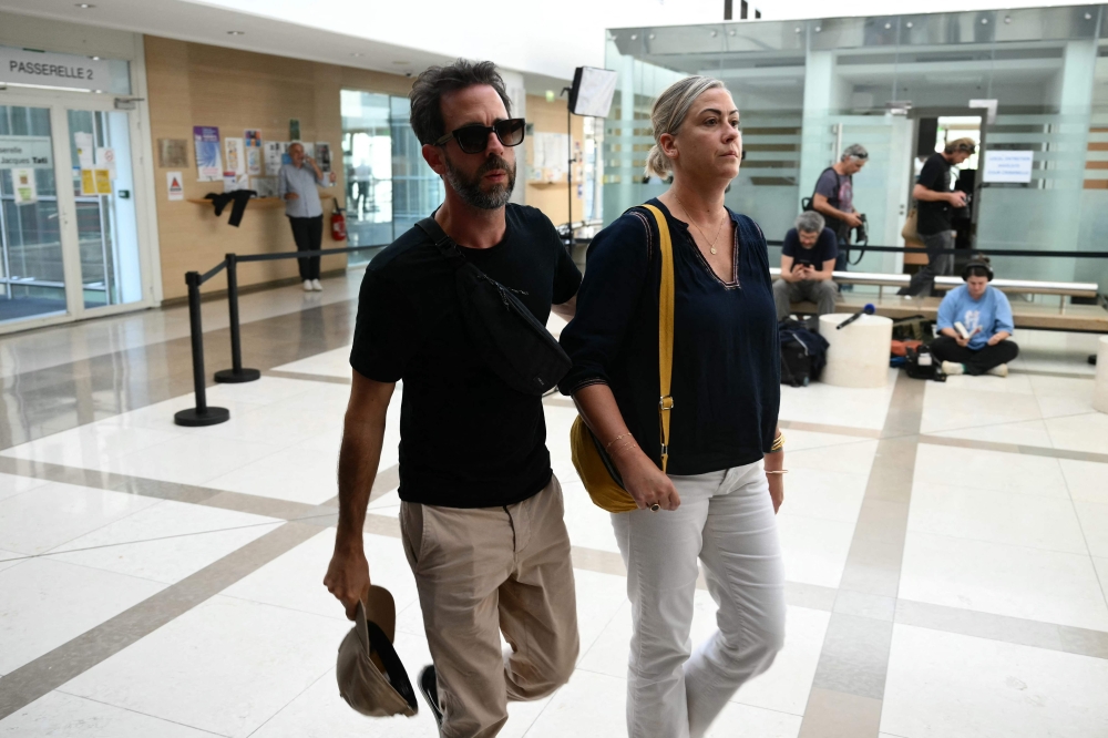Caroline Darian (right) and her brother Florian P. arrives to the courthouse during the trial of their father accused of drugging their mother for nearly ten years and inviting strangers to rape her at their home in Mazan, a small town in the south of France, in Avignon, on September 2, 2024. — AFP pic