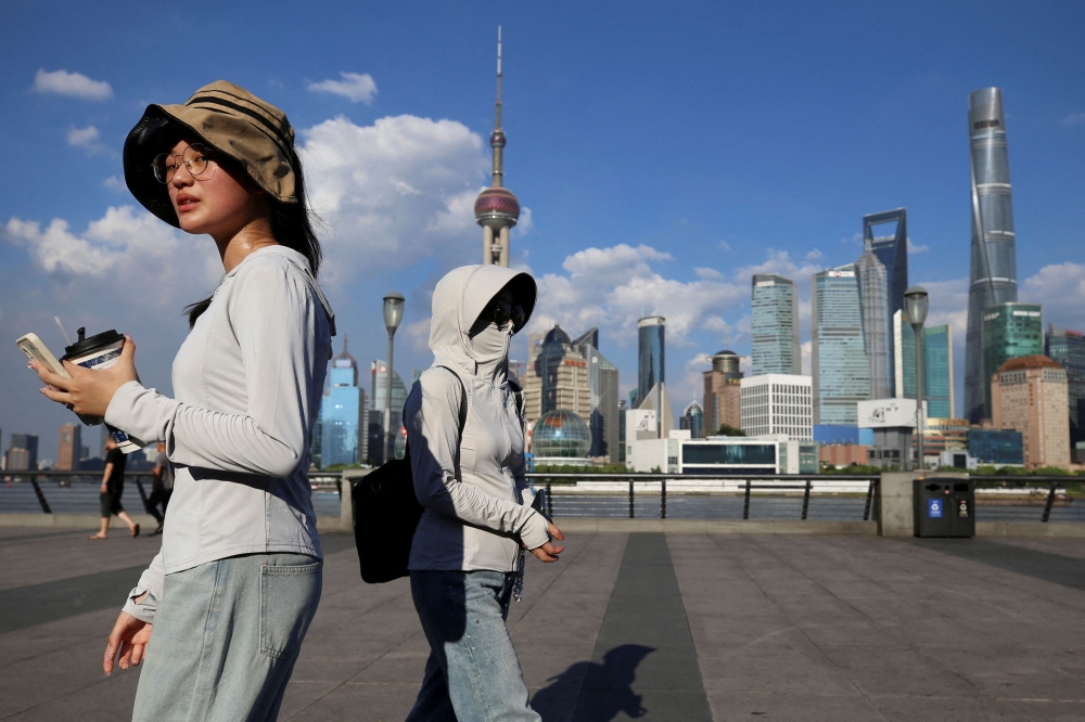 In Shanghai, people cover up to protect themselves against the sun on August 1, 2024. — Reuters pic