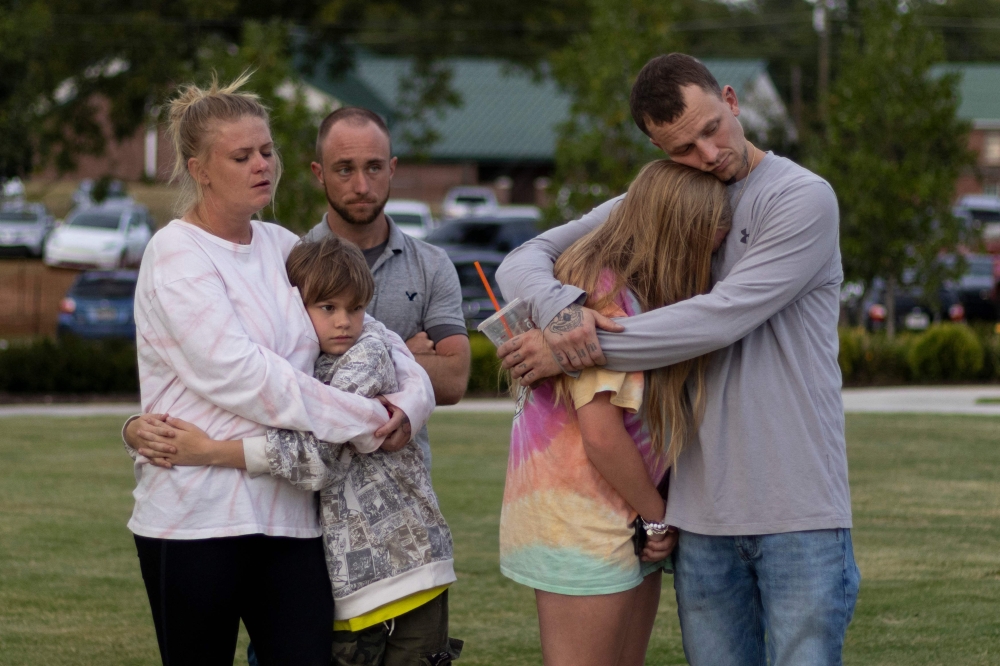 A family embraces during a vigil for the victims of the Apalachee High School shooting at Jug Tavern Park in Winder, Georgia, on September 4, 2024, after a shooting took place. — AFP pic