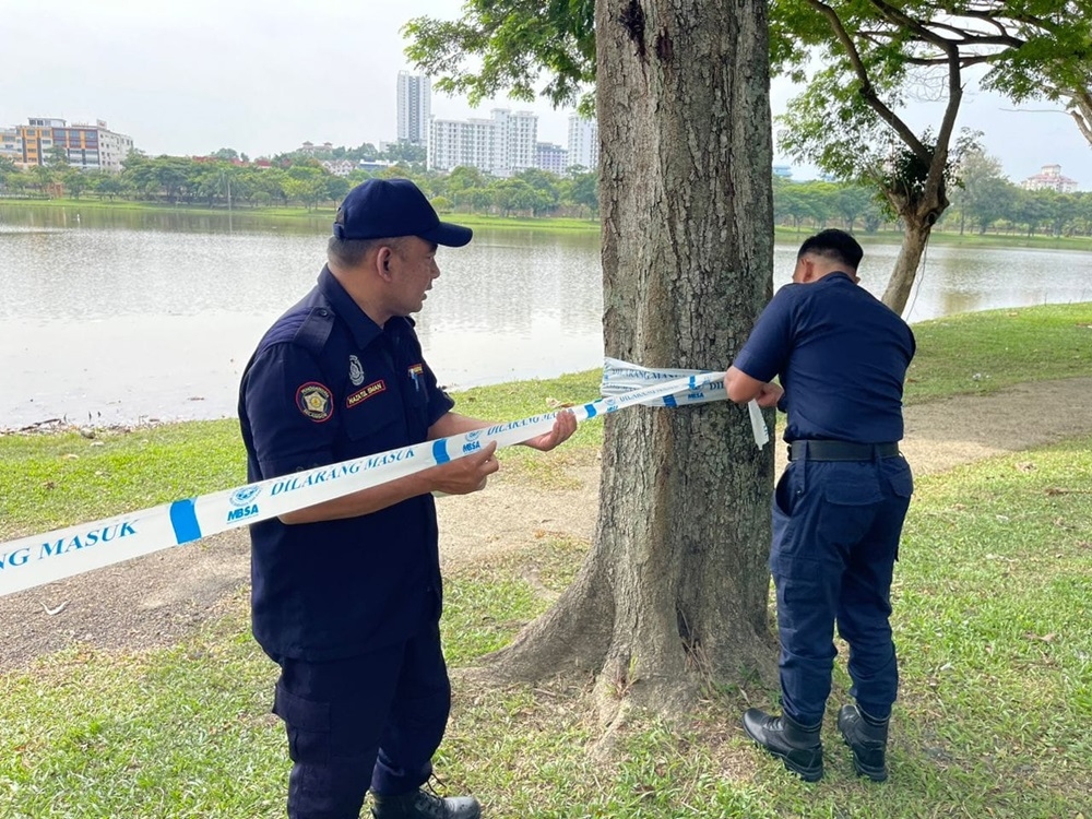 A file photo shows Shah Alam City Council enforcers putting up a barrier to warn the public at the lake area. — Picture via Facebook/Majlis Bandaraya Shah Alam