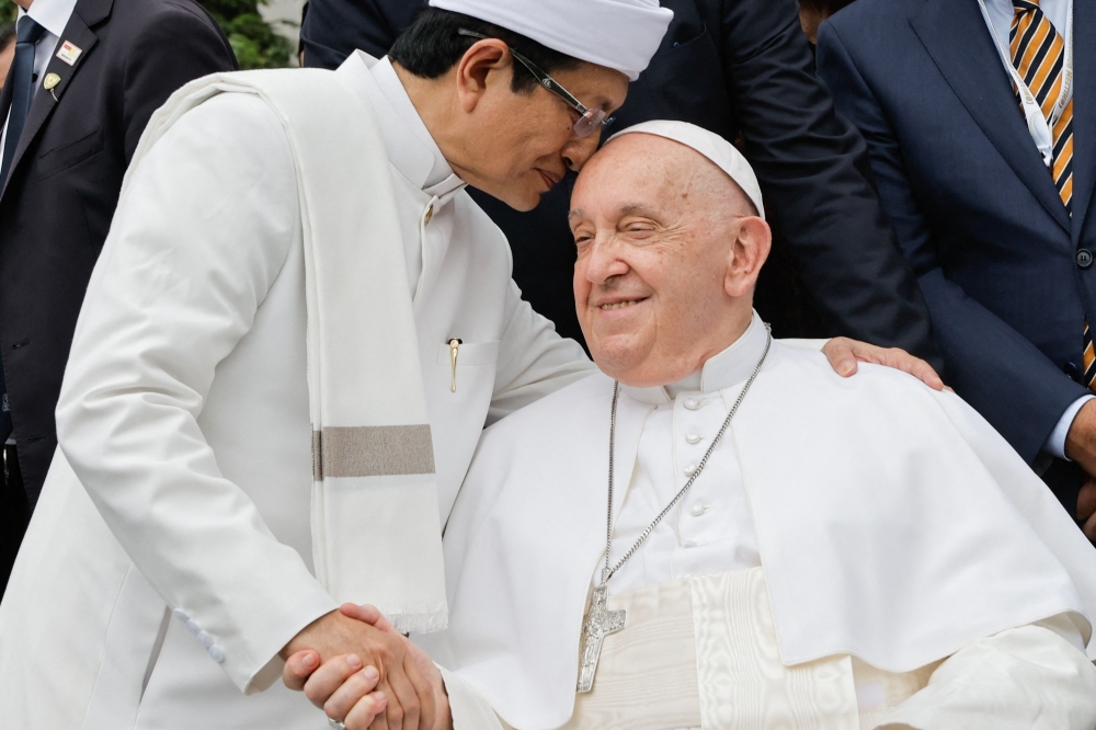 Grand Imam of Istiqlal Mosque Nasaruddin Umar (left) shakes hands with Pope Francis during a family photo following an interreligious meeting with religious leaders at the Istiqlal Mosque in Jakarta on September 5, 2024. — AFP pic