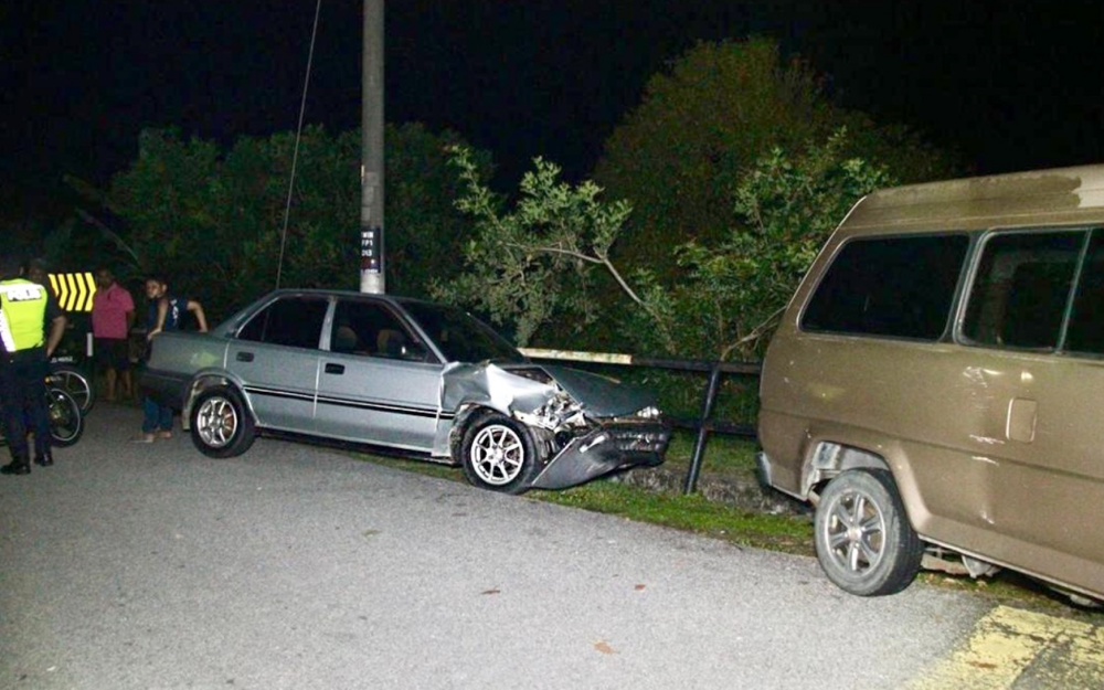 A photo shows the damaged Toyota Corolla and a parked van it earlier hit. — Picture courtesy of the Royal Malaysia Police