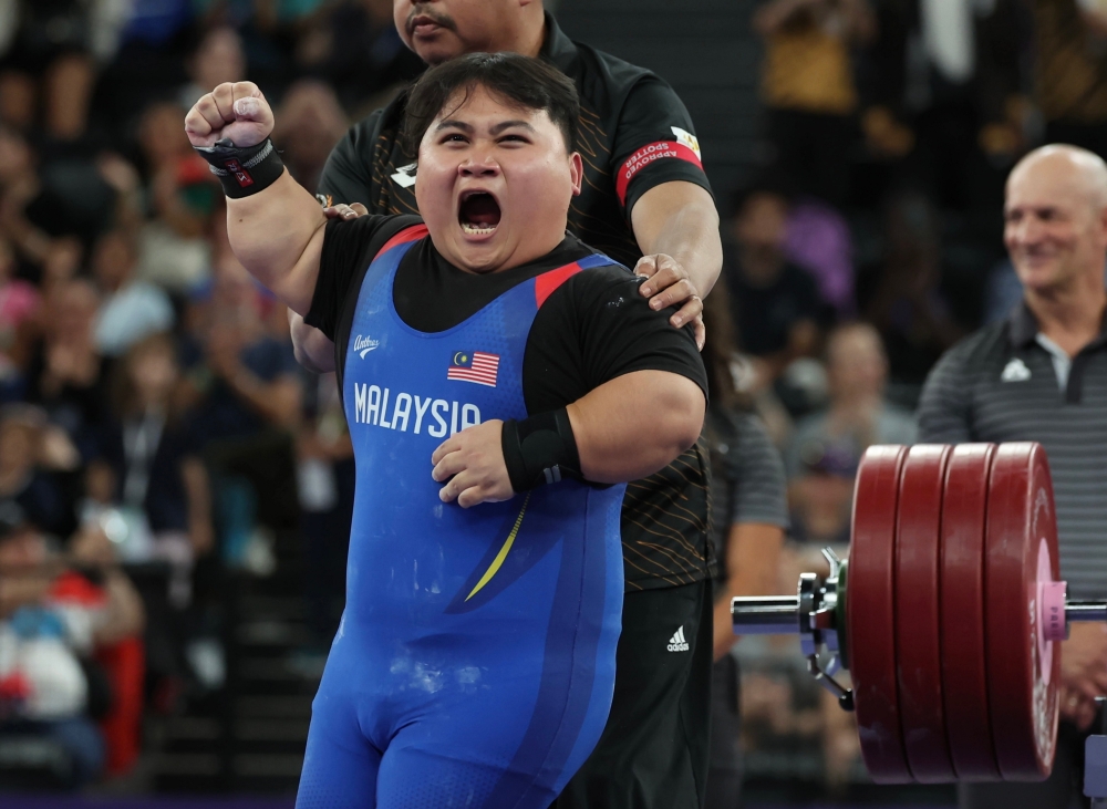National powerlifting athlete Bonnie Bunyau Gustin celebrates retaining his gold medal and shattering his own world record at the 2024 Paris Paralympics in the men’s 72kg category. — Bernama pic