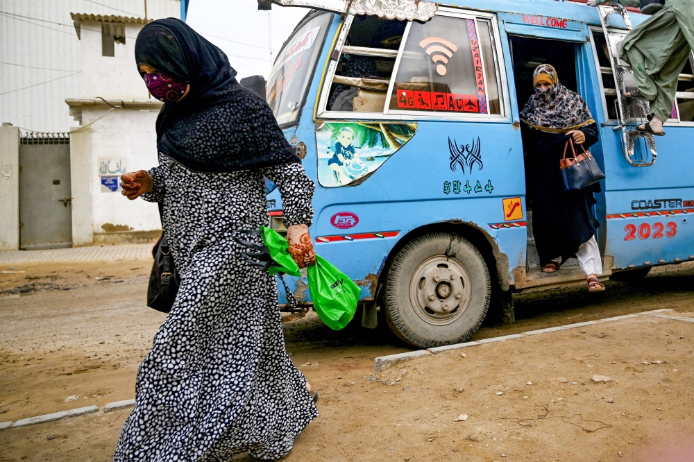 In this photograph taken on August 17, 2024, women employees arrive to work at a leather factory in Karachi.  — AFP pic