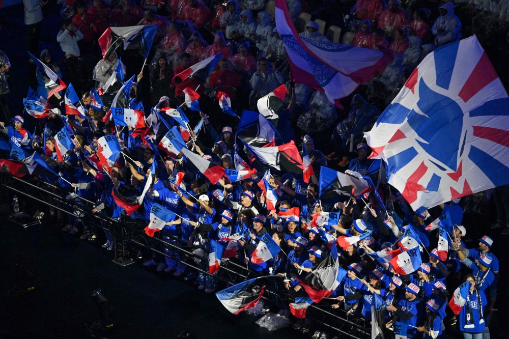 Supporters wave French flags during the Paris 2024 Paralympic Games Closing Ceremony at the Stade de France, in Saint-Denis, in the outskirts of Paris, on September 8, 2024. — AFP pic