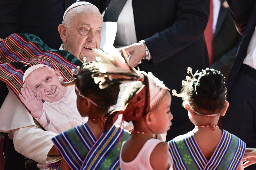 Pope Francis (left) is greeted as he visits the Irmas Alma School for Children with Disabilities in Dili on September 10, 2024. — AFP pic