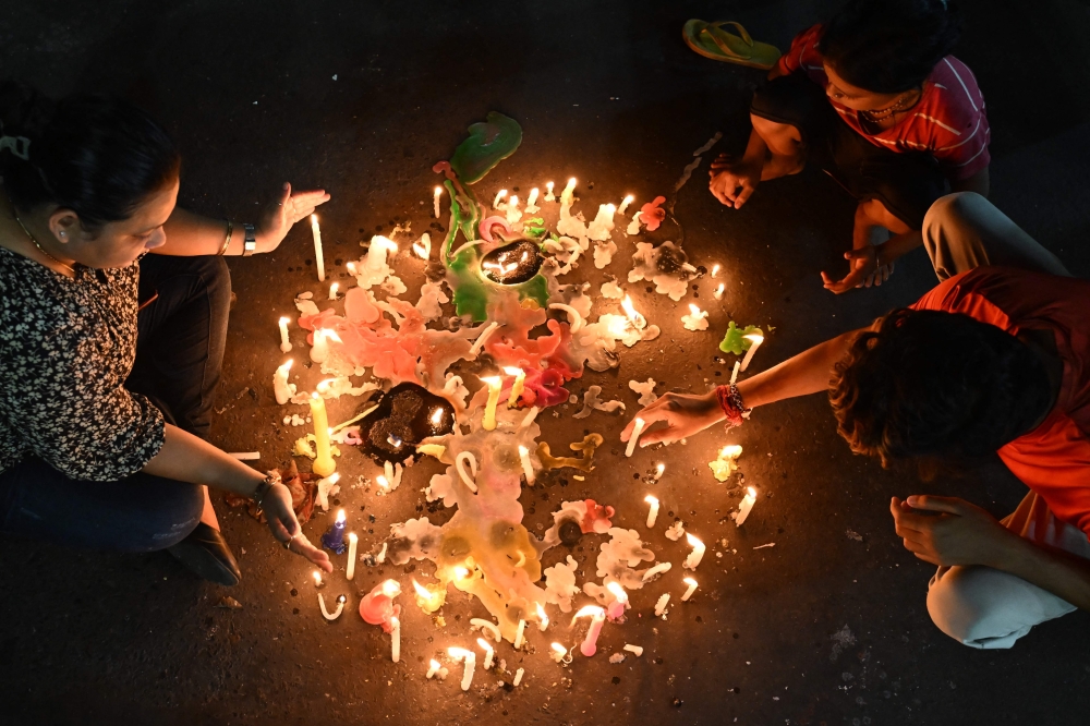 People light candles as they take part in a protest against the rape and murder of a doctor, at the RG Kar Medical College and Hospital in Kolkata, on September 4, 2024. — AFP pic