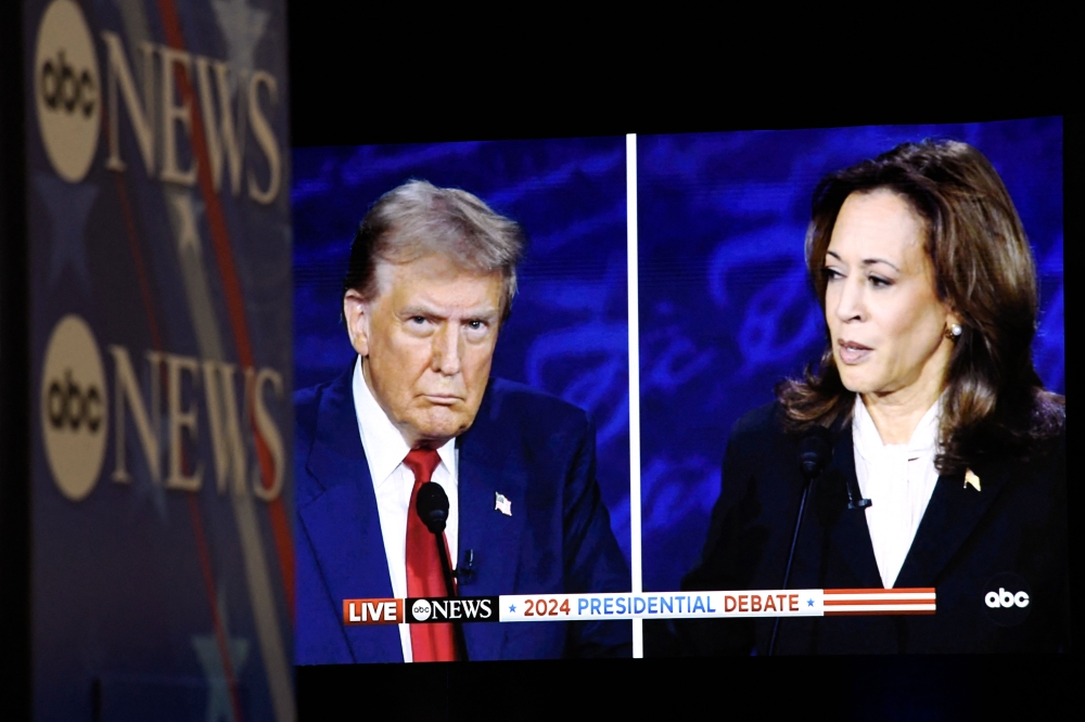 US Vice President and Democratic presidential candidate Kamala Harris and former US President and Republican presidential candidate Donald Trump are seen on a screen in the spin room as they participate in a presidential debate at the National Constitution Center in Philadelphia, Pennsylvania, on September 10, 2024. — AFP pic