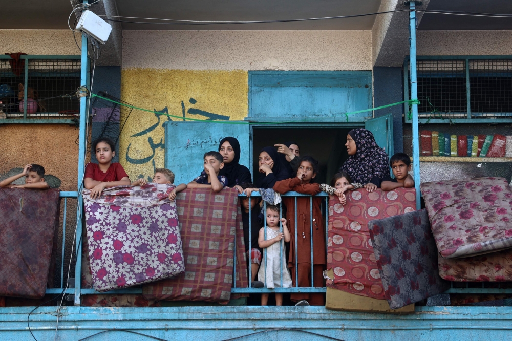Displaced Palestinians taking shelter at a UN school watch after an Israeli air strike hit the site, in Nuseirat in the central Gaza Strip on September 11, 2024, — AFP pic
