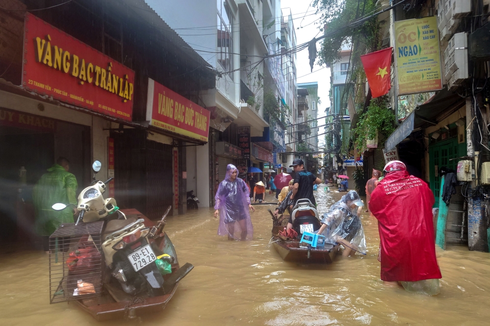 People wade through a flooded street following the impact of Typhoon Yagi, in Hanoi September 11, 2024. — Reuters pic  