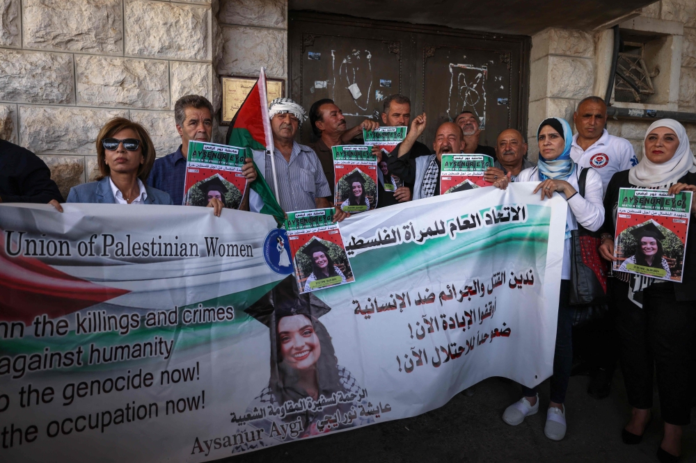 Palestinian activists lift a banner and portraits of slain Turkish-American International Solidarity Movement activist Aysenur Ezgi Eygi during a funeral procession in Nablus in the occupied West Bank on September 9, 2024. — AFP pic