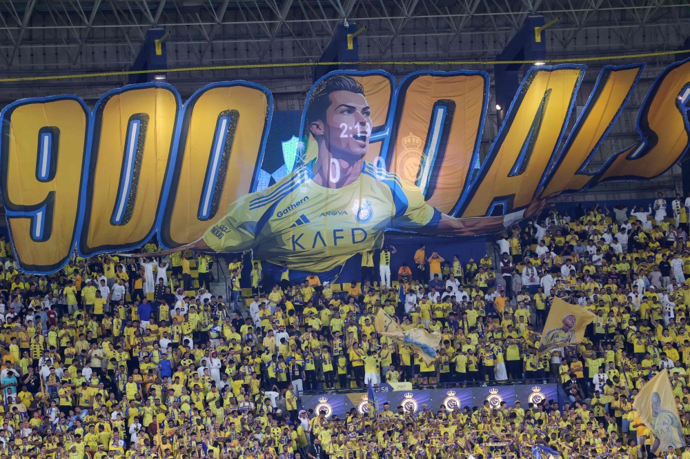 Nassr’s supporters cheer in the stands beneath a large banner depicting team forward Cristiano Ronaldo ahead of the Saudi Pro League football match between Al-Ahli and Al-Nassr in Riyadh September 13, 2024. — AFP pic
