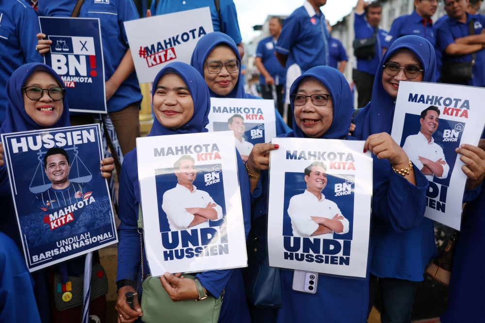 Barisan Nasional supporters hold up posters showing their Mahkota candidate Syed Hussien Syed Abdullah on the route to the Dewan Tunku Ibrahim Ismail nomination centre in Kluang, Johor on September 14, 2024. — Bernama pic