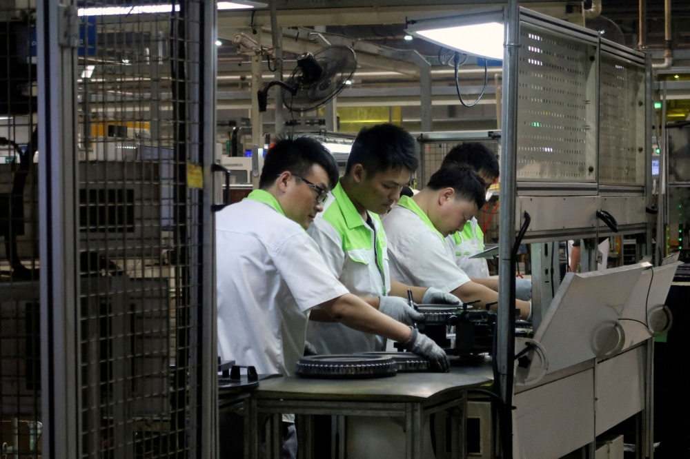 Workers inspect dual-mass flywheels at the production line in an auto parts factory in Nanjing June 27, 2024. — Reuters pic