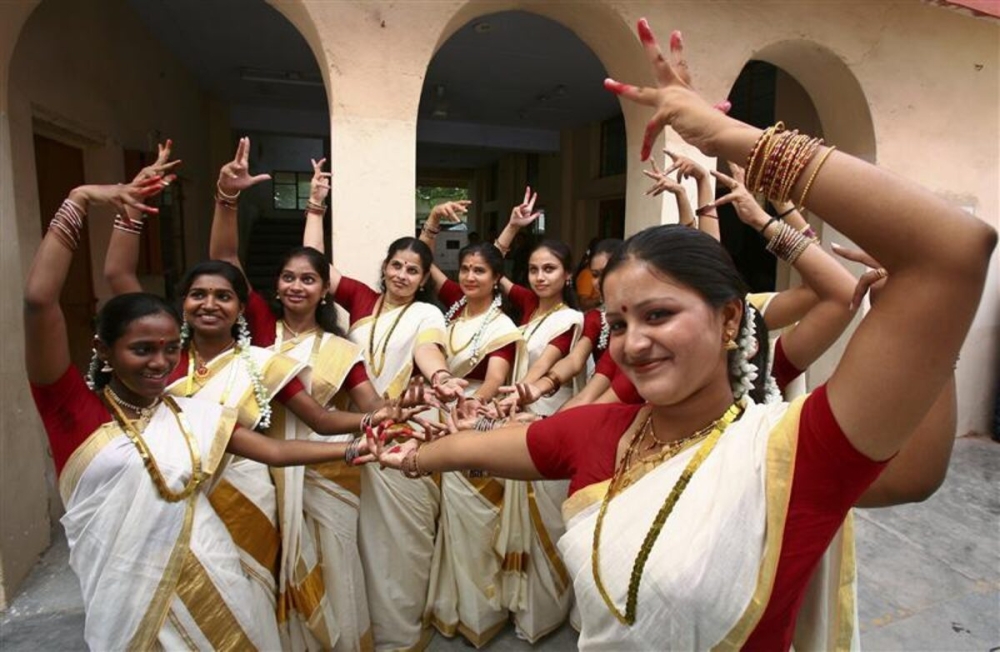 Malayalee women donning traditional white-and-gold kasavu sarees celebrate Onam in India. — Reuters pic