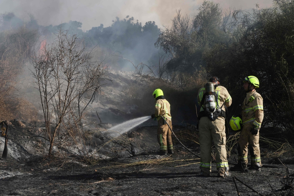 Israeli first responders dousing a fire in an ‘open area’ of Lod near Tel Aviv in central Israel where a missile from Yemen fell on September 15, 2024. — AFP pic