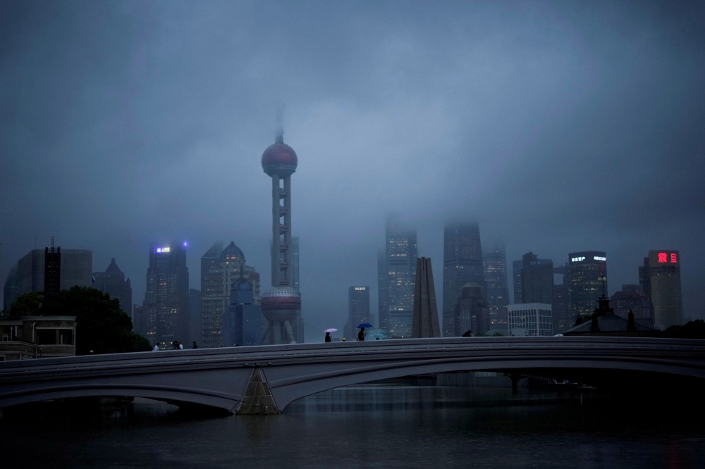 File picture of people walking with umbrellas on a bridge amid rains and winds brought by Typhoon Muifa, in Shanghai, China September 14, 2022. Chinese authorities prepared for heavy rain on Sunday as a strong typhoon approached the country’s heavily populated eastern seaboard. — Reuters pic 
