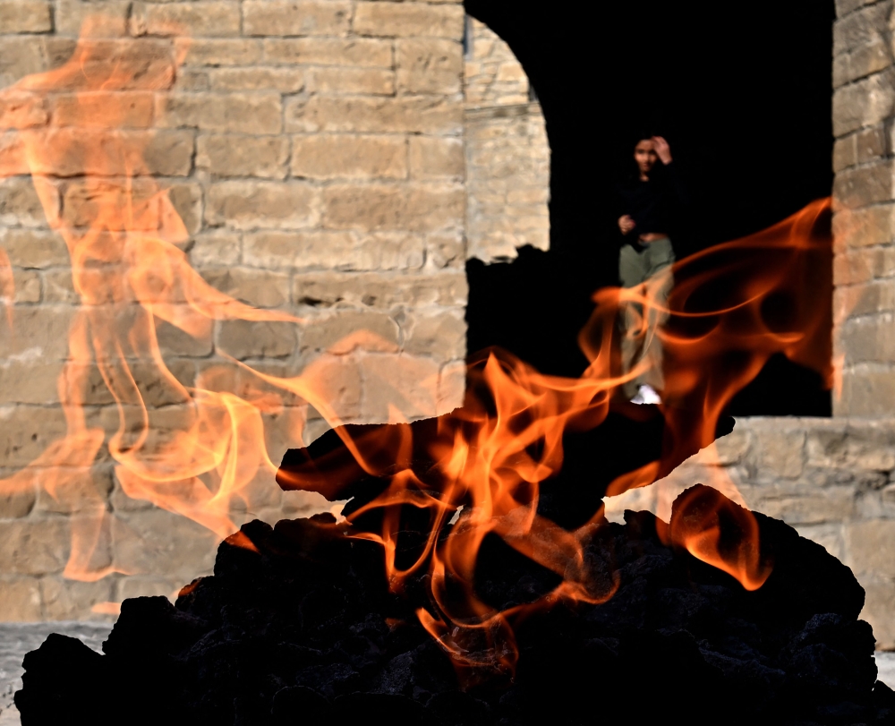 People visit Yanardag, a natural gas fire which blazes continuously on a hillside on the Absheron Peninsula near the Azerbaijani capital of Baku on July 22, 2024. Flames soar into the air from a sandstone outcrop on a hillside of the Absheron peninsula near Baku, the capital of Azerbaijan, as it prepares to host the COP29 climate conference from November 11 to November 22, 2024. — AFP pic