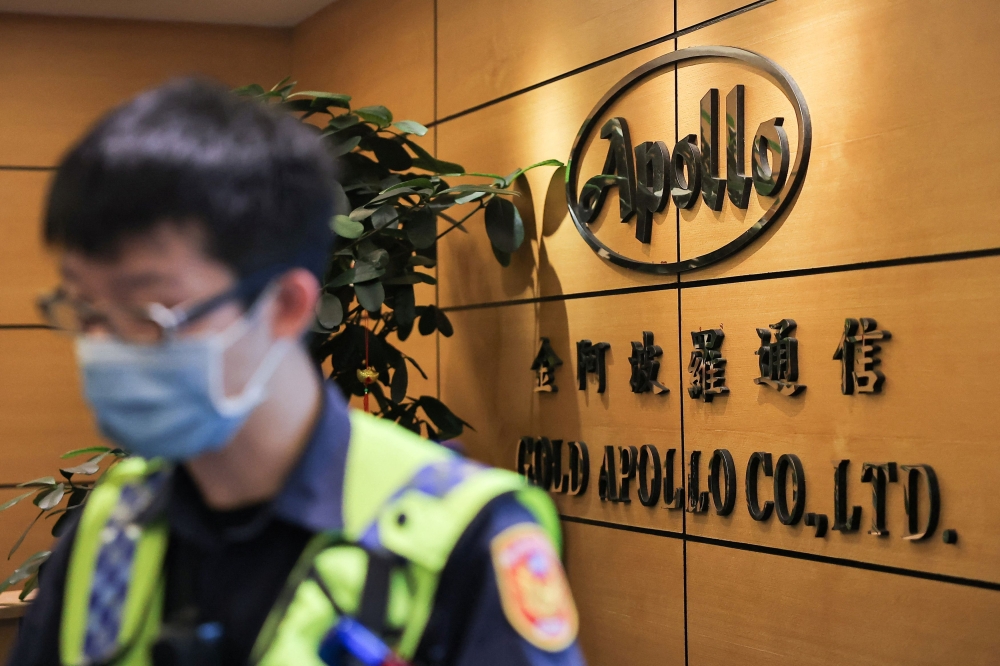 Police arrive at the Gold Apollo office in Taiwan. — Reuters pic