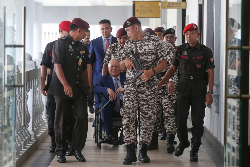 Former Prime Minister Datuk Seri Najib Razak is pictured in a wheelchair at the Kuala Lumpur High Court Complex today. — Picture by Yusof Mat Isa