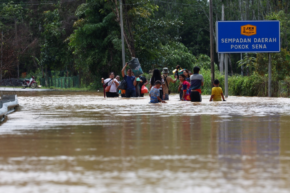 Residents in Derang area are seen carrying essential items after their homes were submerged in Derang, near Pokok Sena, Kedah, September 18, 2024. — Bernama pic 