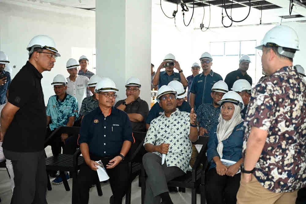 During a recent visit, Higher Education Minister Datuk Seri Zambry Abdul Kadir (seated) was briefed on the UMS Hospital project.