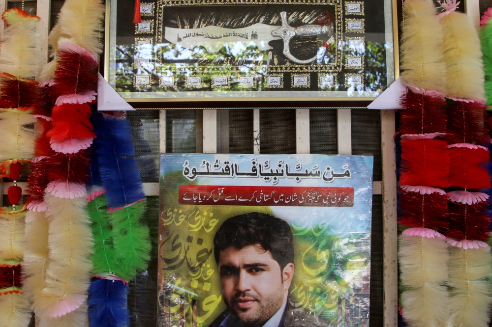 A view shows a portrait of police officer Saayd Muhammad Sarhadi, who opened fire and killed a man in custody on blasphemy allegations at a police station, with a decorative piece of dagger and garlands, presented to his father by guests at his residence in Quetta, Pakistan September 18, 2024. — Reuters pic