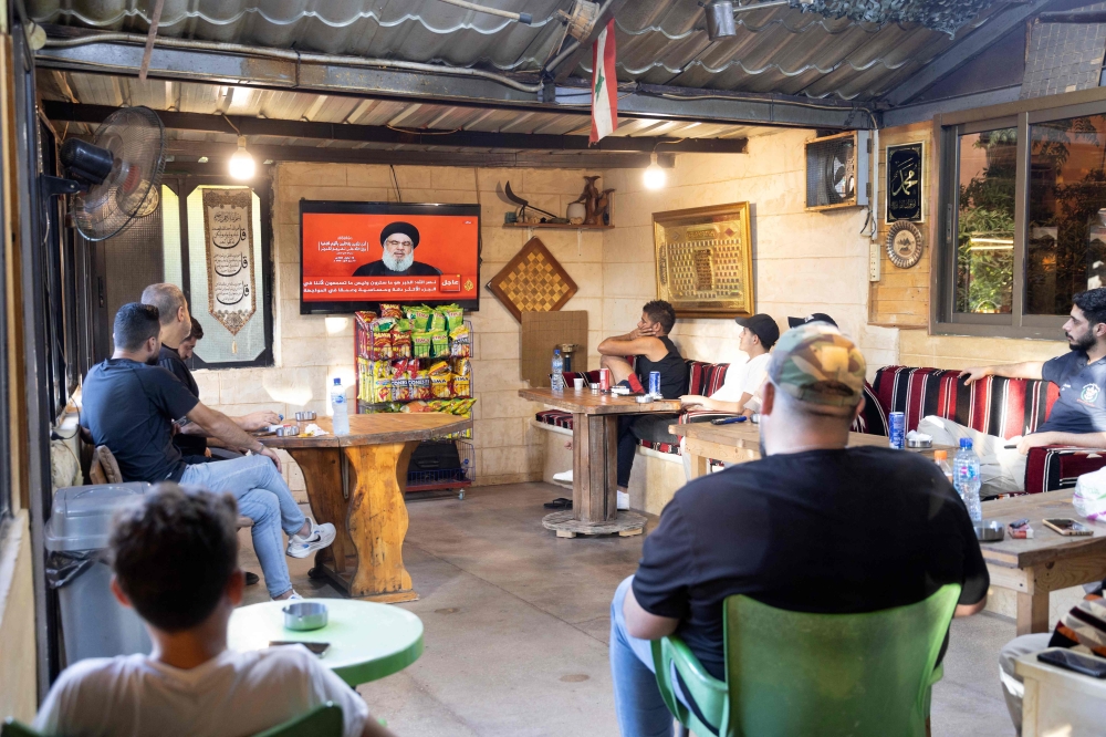 People attend a televised speech by the leader of the Hezbollah movement Hassan Nasrallah at a cafe in the southern Lebanese village of Zawatar on September 19, 2024. — AFP pic