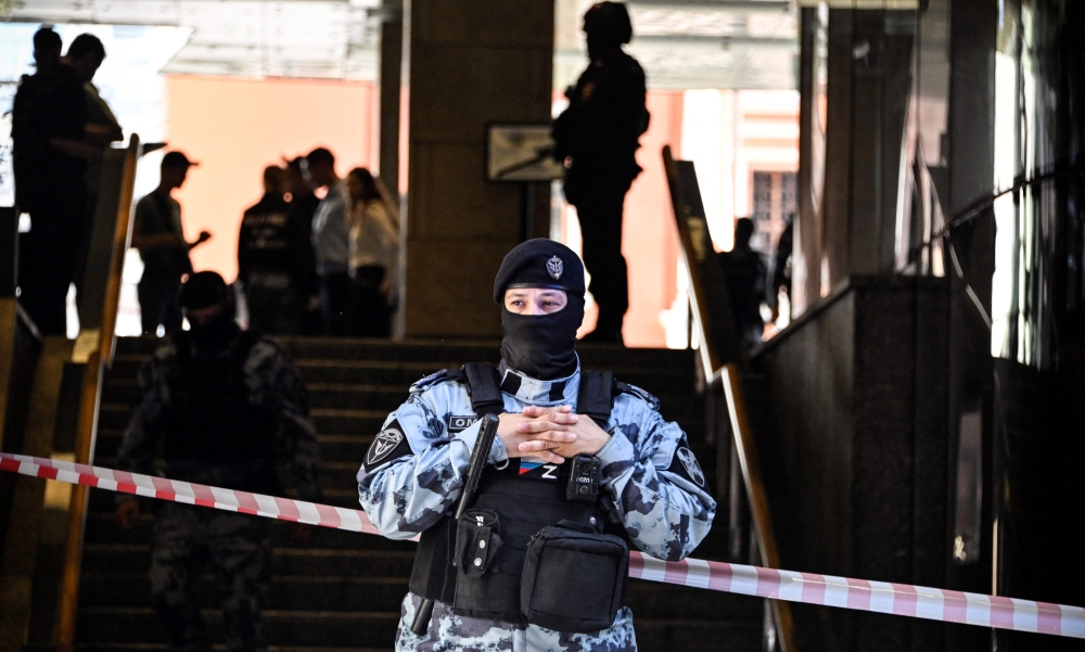 A Russian police officer blocks the entrance to the office building of Russian retailer Wildberries after an attempted raid in central Moscow on September 18, 2024. — AFP pic
