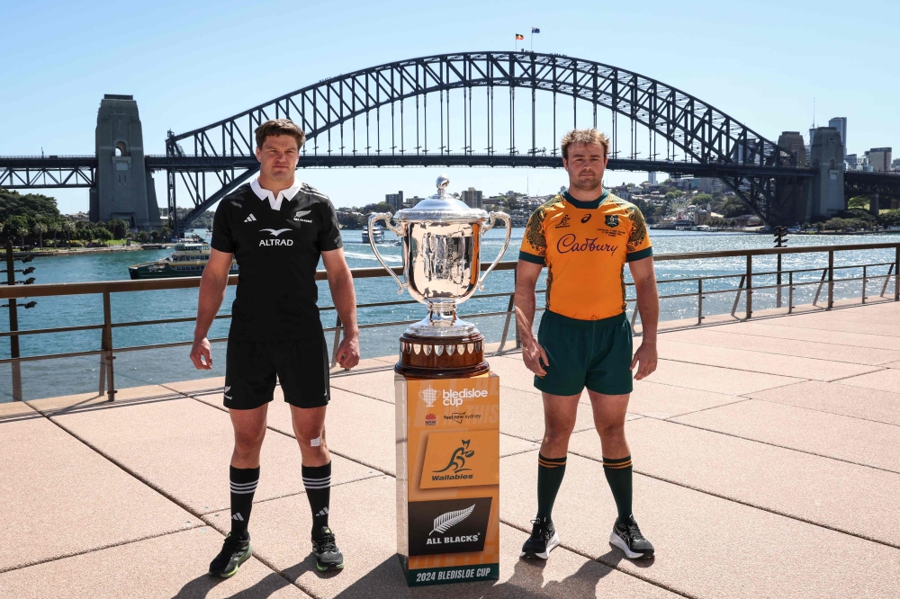 Australia's Wallabies captain Harry Wilson (right) and New Zealand All Blacks captain Scott Barrett stand next to the Bledisloe cup trophy in front of the Sydney Harbour Bridge on September 20, 2024. — AFP pic