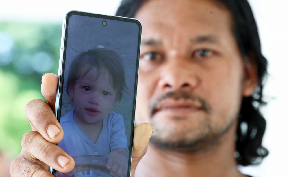 Mohd Hamidan Hashim, 38, shows a picture of his granddaughter Nur Aisha Misya Afifah Abdul Fattah, 2, who was found drowned in a drain the day before in Lorong Seri, Jalan Langgar, Alor Setar September 20, 2024. — Bernama pic