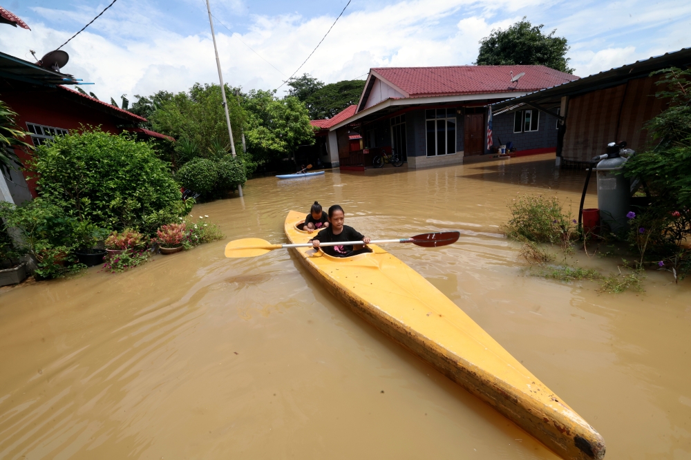 The overflowing Kedah River gives three sisters Syalia Izz Zara, 12, Syasya Auni Amani, 10, and Syafia Afrin Nafeesa Mohd Shaharuddin, 7, the opportunity to go kayaking in the yard of their relative's house in Kampung Titi Gajah during a survey of the floods around Alor Setar September 20, 2024. — Bernama pic