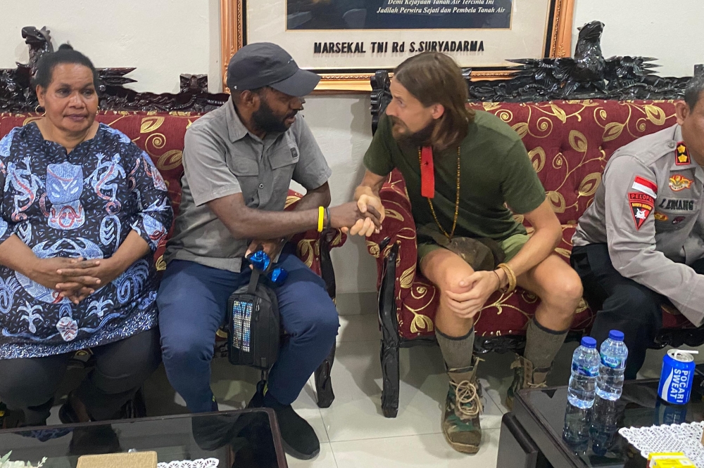 This screen grab from handout video footage taken and released on September 21, 2024 by the Cartenz Peace Task Force shows New Zealand pilot Phillip Mehrtens (second right), who was snatched by rebels in Indonesia's restive region of Papua in February last year, following his release at a press conference in Timika. —  Cartenz Peace Task Force via AFP