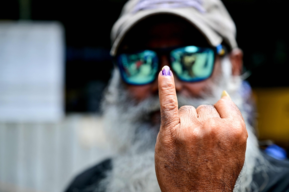 More than 17 million people are eligible to vote in the election, with more than 63,000 police deployed to guard polling booths and counting centres in schools, temples. — AFP pic