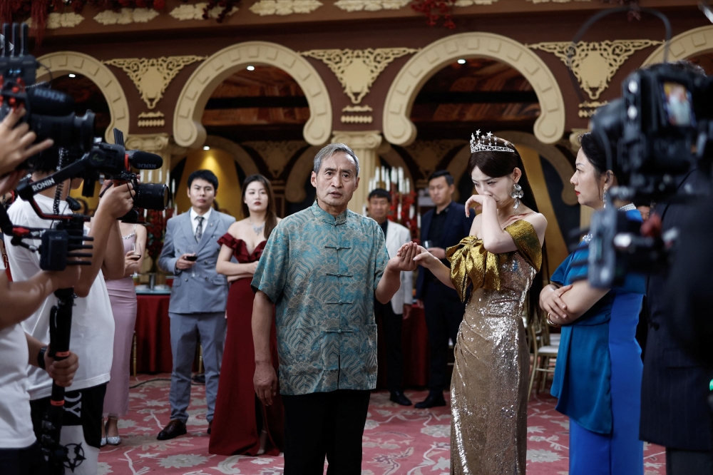 Zhu Jian, 69, on the set of a micro movie during a filming session at a banquet hall, in Zhengzhou, Henan province. — Reuters