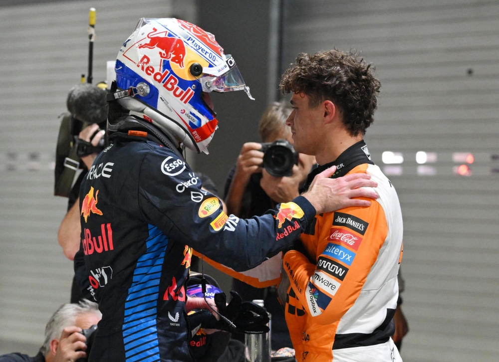 Lando Norris celebrate with Red Bull's Max Verstappen at the Marina Bay Street Circuit, Singapore. — Reuters pic
