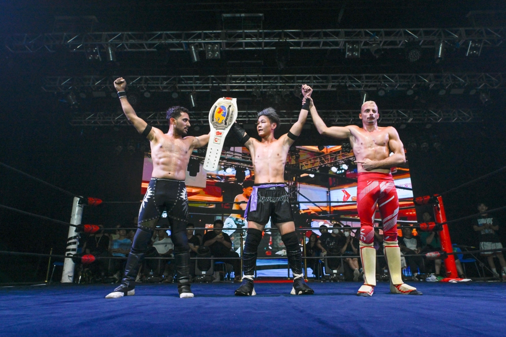 This picture taken on September 14, 2024 shows Wang Tao (centre) celebrating after winning a Middle Kingdom Wrestling (MKW) championship event in Shanghai. Despite a promising potential domestic market, the Chinese pro wrestling community has been battling for recognition and financial stability for decades. — AFP pic