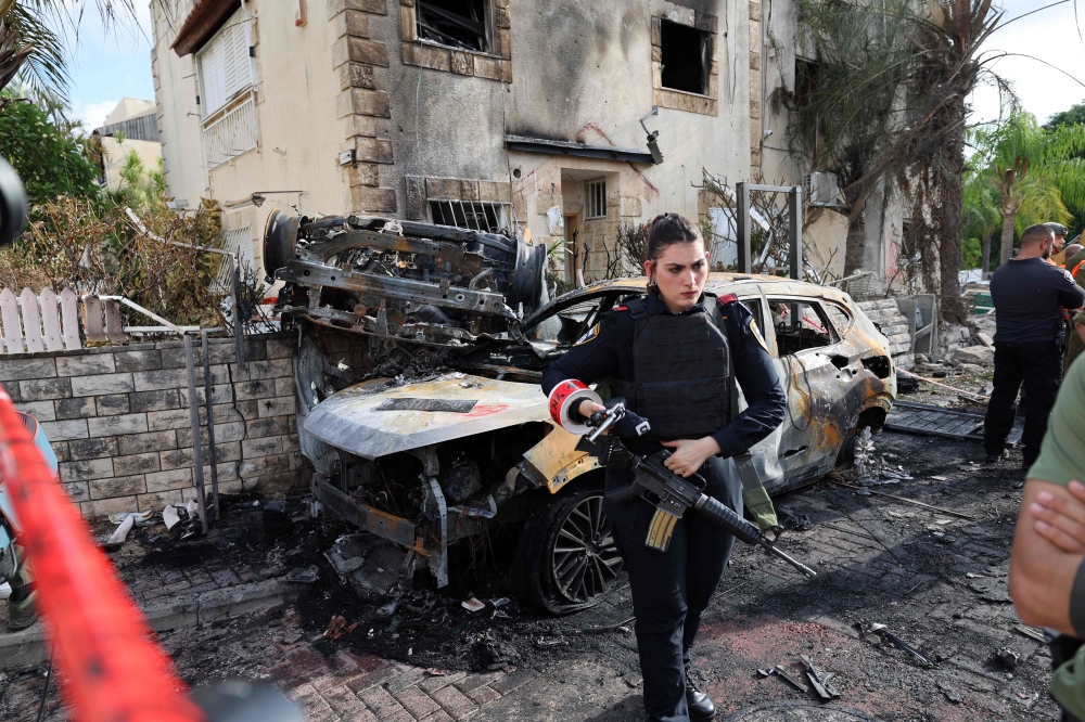A member of the Israeli security forces stands guard inside a cordoned-off area in Kiryat Bialik in the Haifa district of Israel, targeted by a reported strike by Lebanon’s Hezbollah on September 22, 2024. Hezbollah said yesterday that it targeted military production facilities and an air base near north Israel’s Haifa after the Israeli military pounded south Lebanon and said it targeted thousands of rocket launcher barrels. — AFP pic