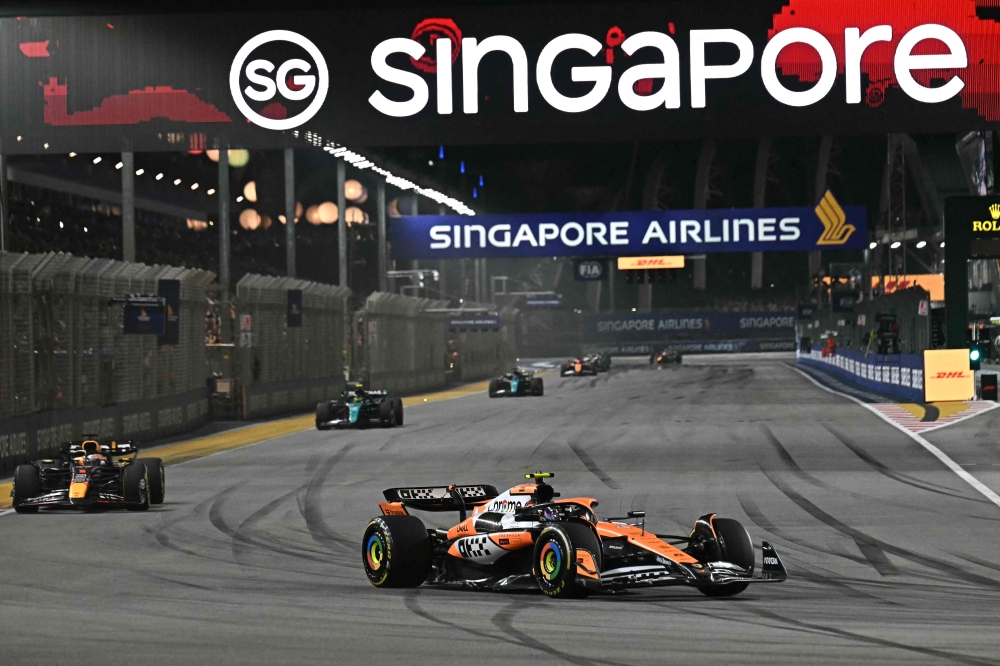McLaren's British driver Lando Norris (centre) drives during the Formula One Singapore Grand Prix night race at the Marina Bay Street Circuit in Singapore September 22, 2024. — AFP pic