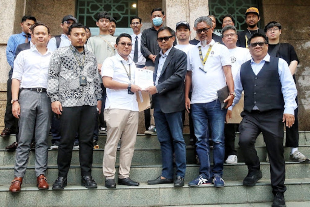 Malaysia Retail Electronic Cigarette Association (MRECA) president Datuk Adzwan Manas (centre) handing over a memorandum protesting the new regulations to a representative from the Prime Minister’s Office. — Picture by Choo Choy May 