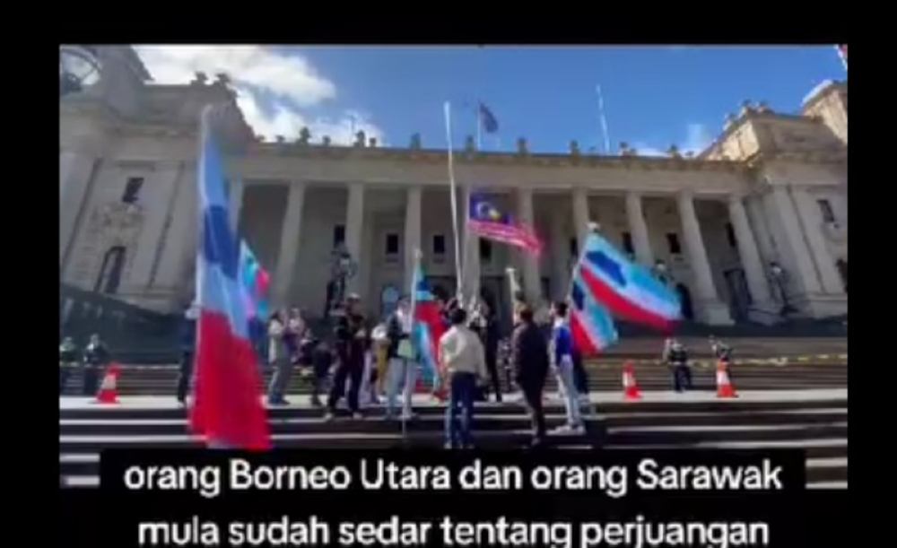 A screengrab of the video lasting eight minutes and 13 seconds that went viral on social media showing a group of individuals lowering the Jalur Gemilang and raising the flags of Sabah and Sarawak in front of the Victoria Parliament building in Melbourne, Australia.