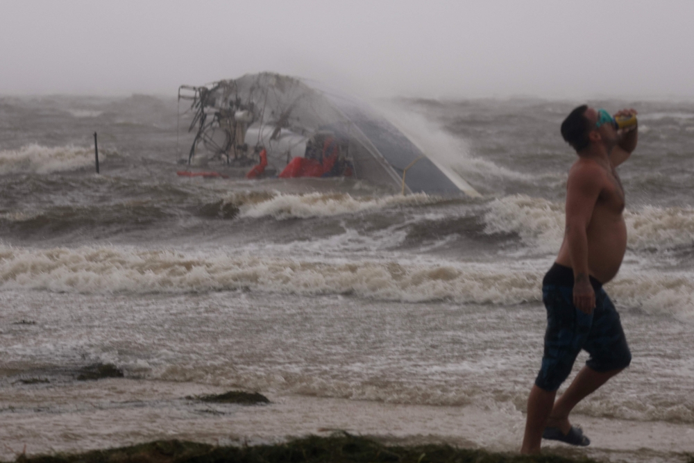 A capsized boat washes ashore as Hurricane Helene churns offshore in St. Peteersburg, Florida, on September 26, 2024. — AFP pic